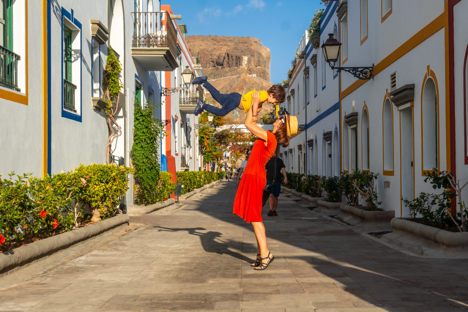 Mother having fun with her raised son in the port of the town Mogan in Gran Canaria. Family vacation